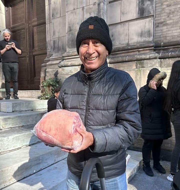 customer holds a frozen pork shoulder