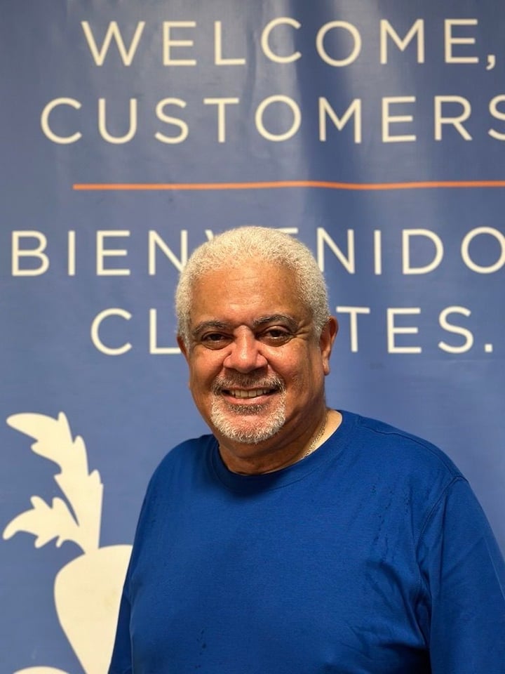 A man smiles at the viewer, standing in front of WSCAH's welcome sign.