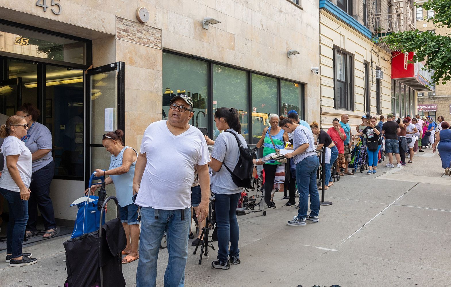 A long line of people spans down the length of a city street.