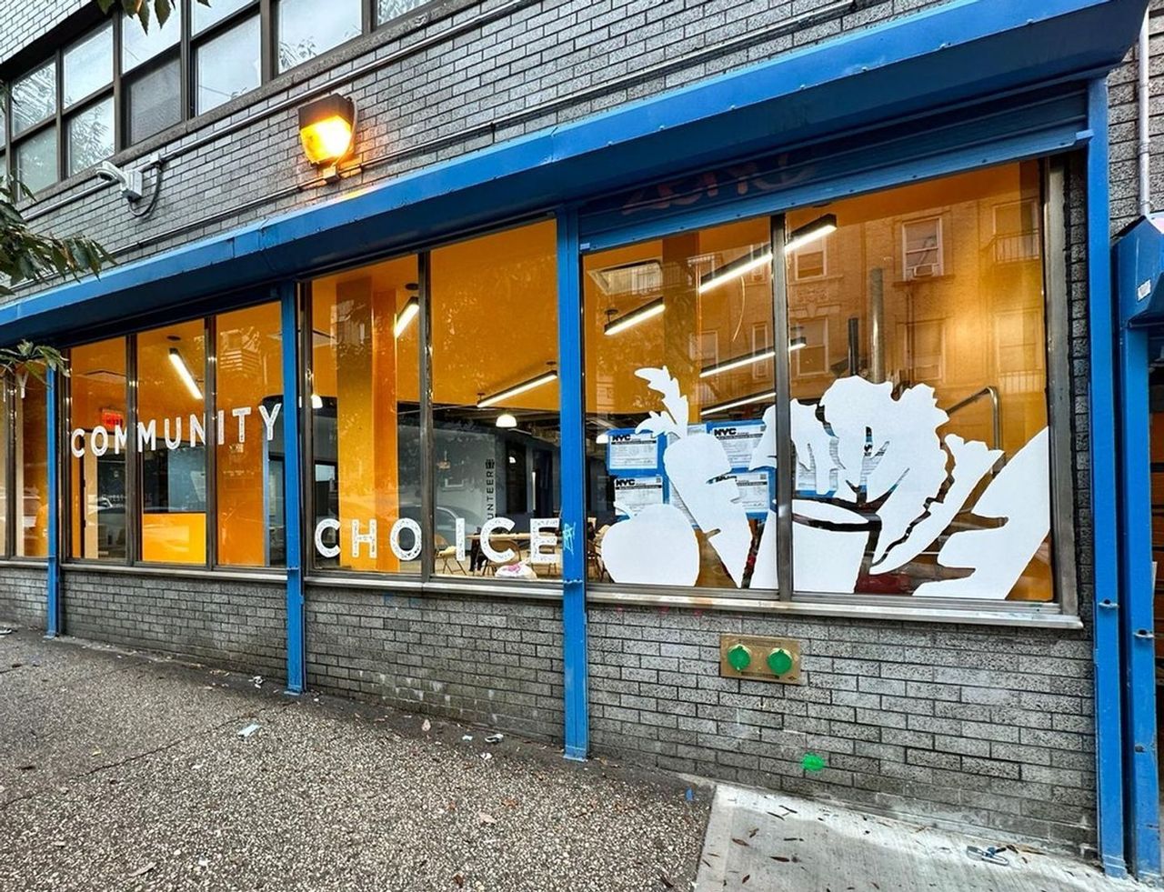 WSCAH's warehouse location, as viewed from 180th street. Large windows are painted with decals of fruits and vegetables, as well as the words "Dignity Community Choice"