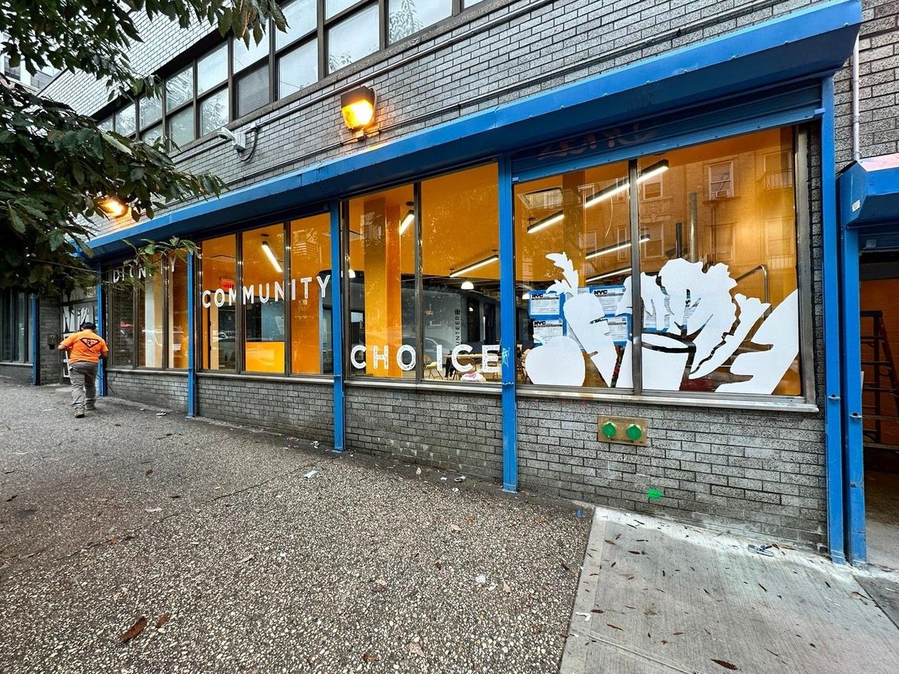 WSCAH's warehouse location, as viewed from 180th street. Large windows are painted with decals of fruits and vegetables, as well as the words "Dignity Community Choice"