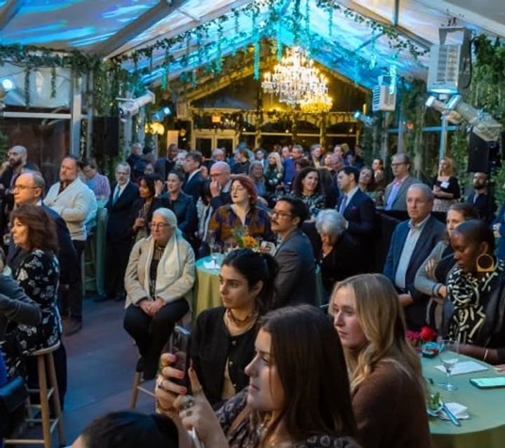 A room of WSCAH supporters, board members, volunteers, and staff sit in the iconic Taven on the Green's South Terrace Atrium during WSCAH's 'Plentiful Plates' fundraiser.