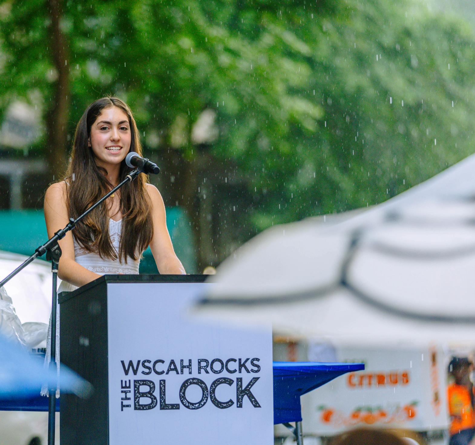 Student reading on the stage at ROCKS THE BLOCK